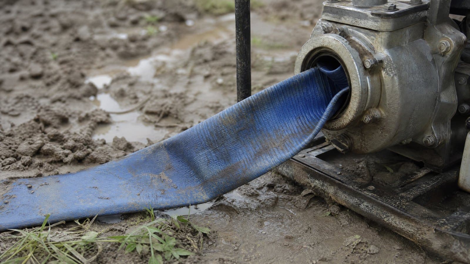 Blue lay flat hose collapsed flat at a pump inlet after being used on the suction side