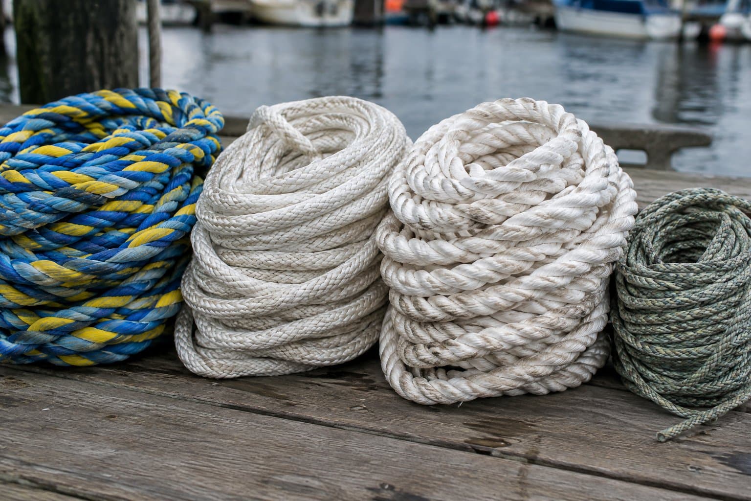 Coils of polypropylene, nylon, polyester and HMPE fibre rope side by side on a dock