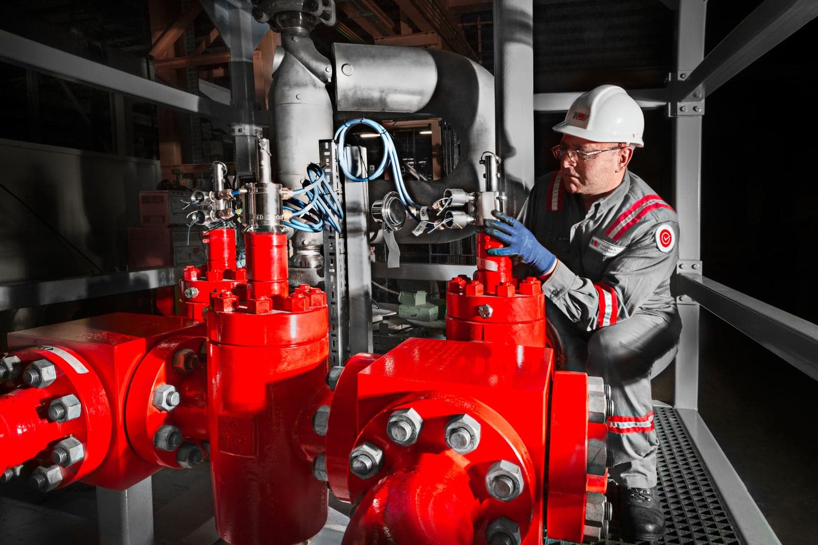 Technician at a red multi-well manifold, 4-well, 1502 series, 15,000 psi