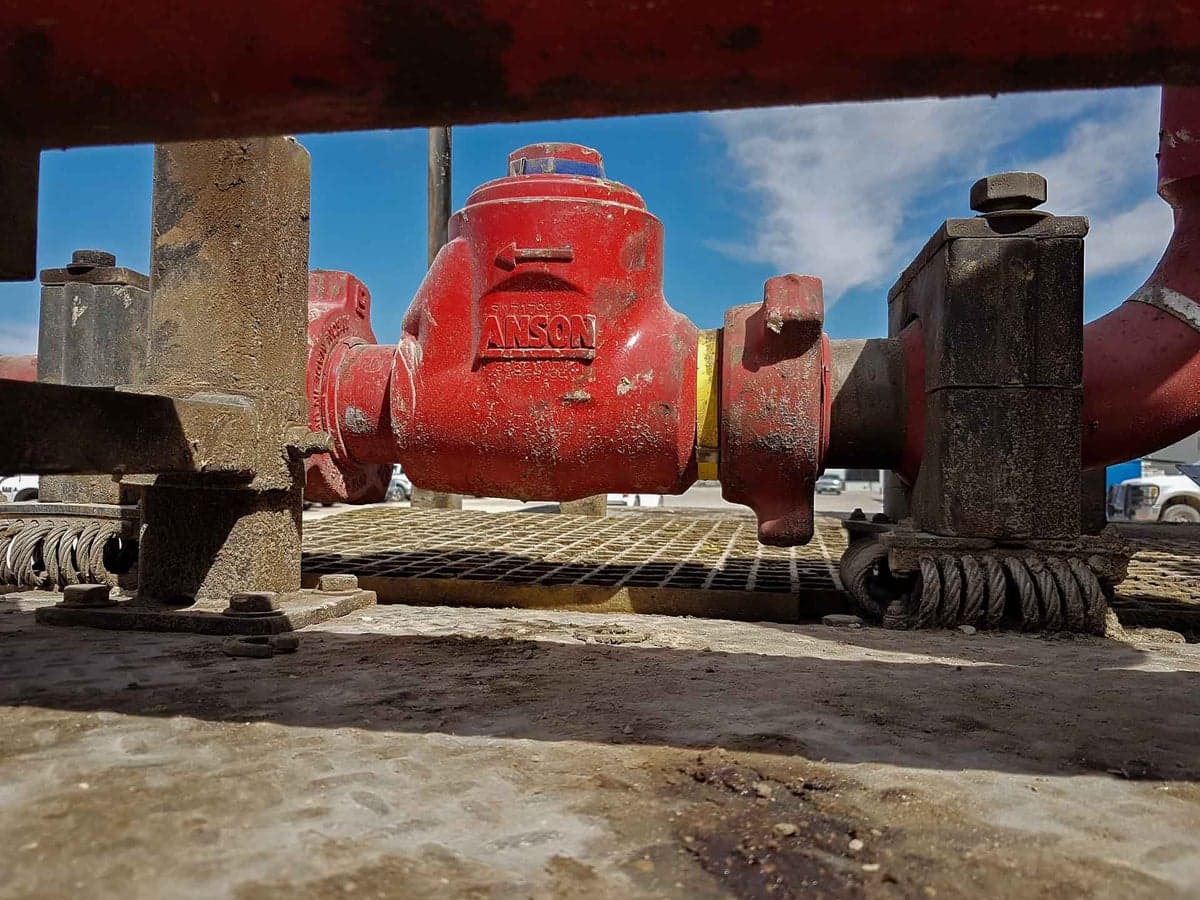 Red swing check valve on a rig flowline (2 in × 602 F×M listing)