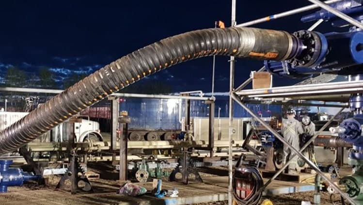 Frac hose assembly connected on a wellsite at night