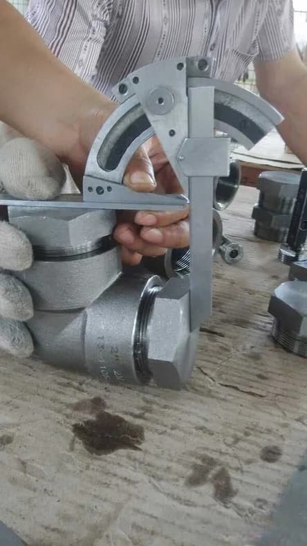 Bevel protractor set against a forged fitting to read an angle