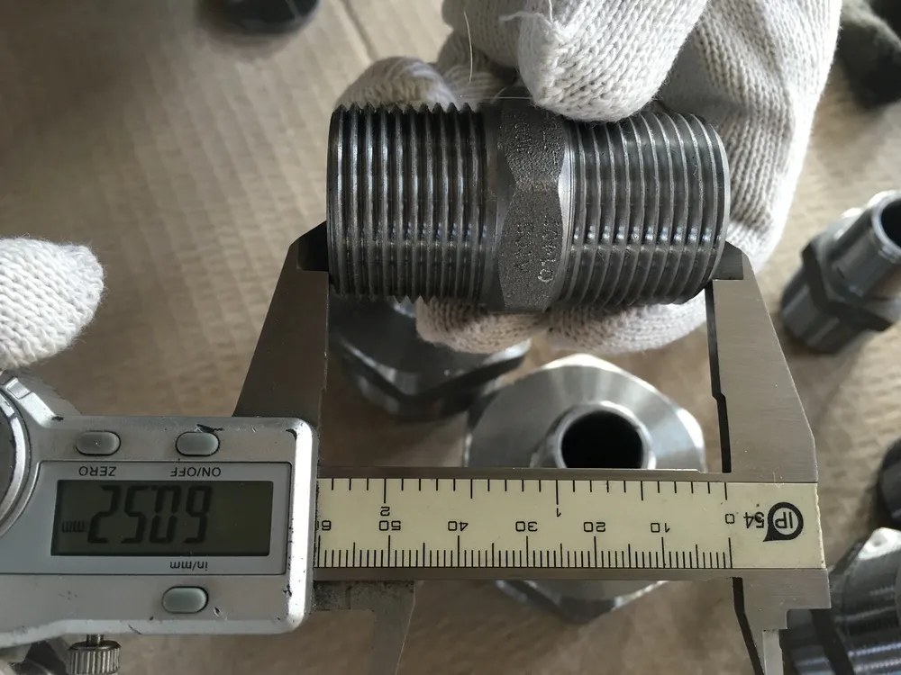 Digital caliper reading the overall length of a hex nipple